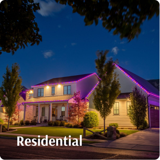 A two-story house with pink-purple lights outlining the roof, surrounded by trees and shrubs at dusk. The word "Residential" is displayed at the bottom left.